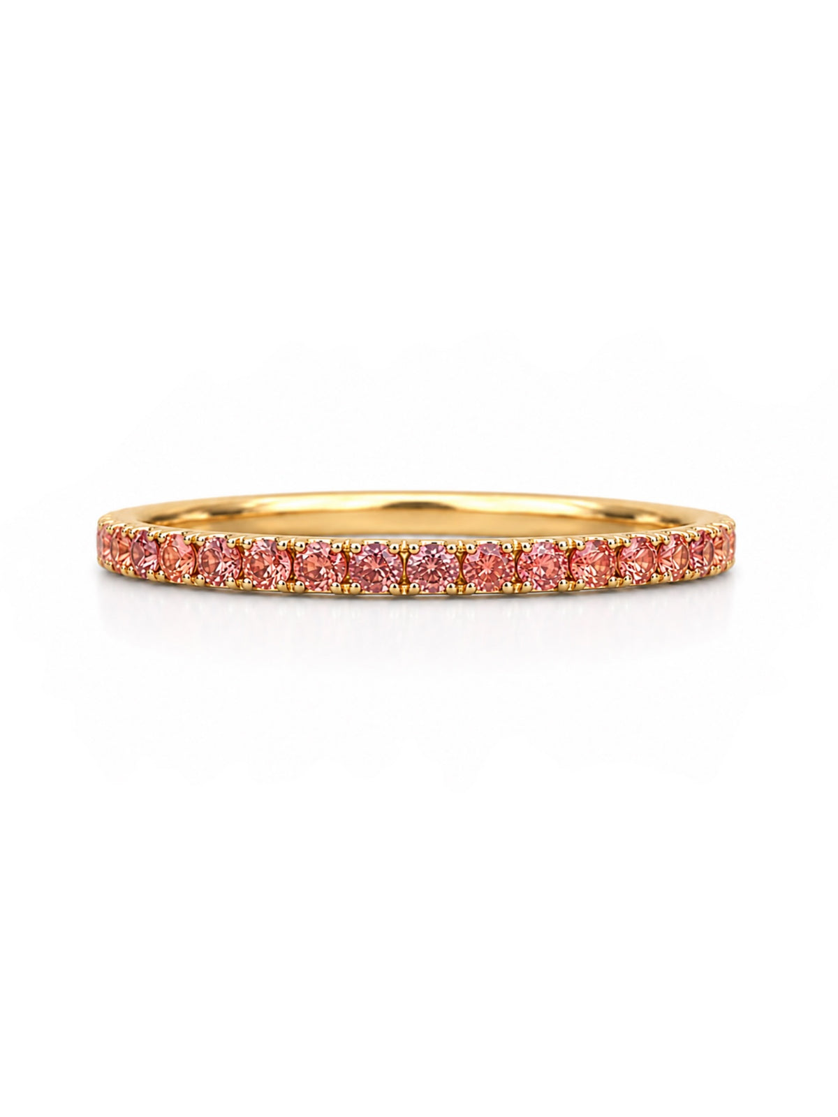 A delicate yellow gold eternity ring featuring a continuous row of small, round-cut orange pink gemstones, shown on a clean white background.